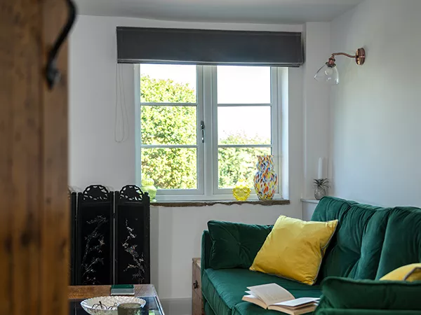 A home interior featuring a window and dark green sofa