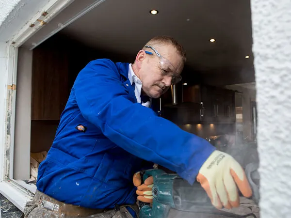 A window fitter prepares a window aperture